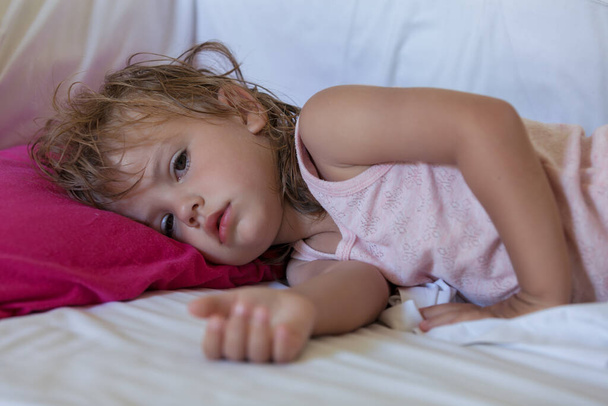 сонна маленька дівчинка на подушці
 - Фото, зображення