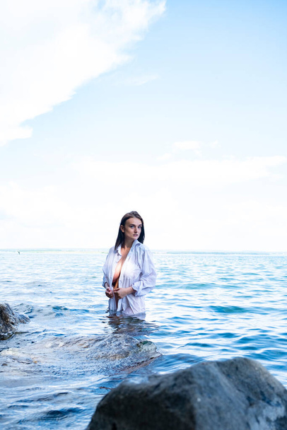 Голая девушка в мокрой рубашке стоит в воде
 - Фото, изображение