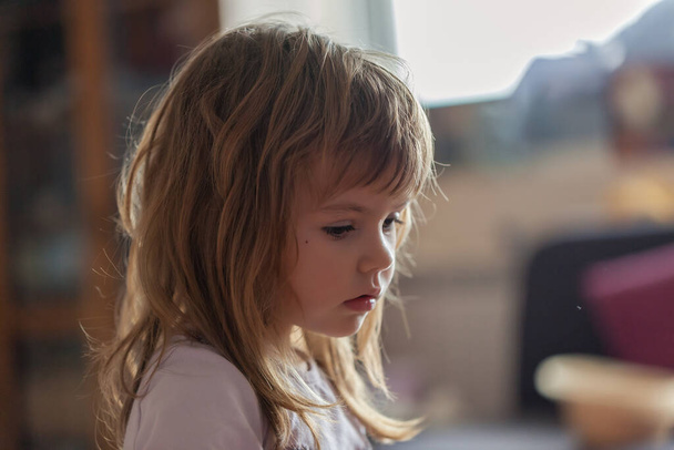 εκφράσεις στο πρόσωπο ενός γλυκού κοριτσιού, ενώ παίζει στο σπίτι - Φωτογραφία, εικόνα