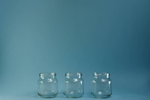 Three glass jars at the bottom of the center horizontal row. - Foto, Imagen