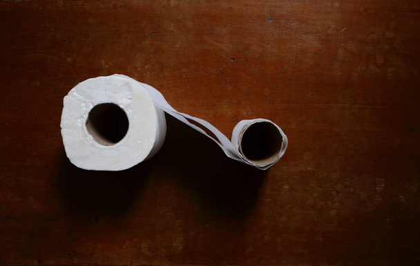 Gros plan deux rouleaux de papier toilette reliés entre eux placés sur une table en bois, mise au point sélective, vue grand angle - Photo, image