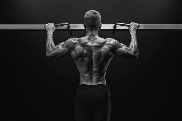 Potere bodybuilder ragazzo muscolare facendo pullup in palestra. Fitness uomo - Foto, immagini