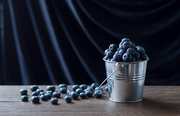 blueberries in a metal bucket in the evening - Foto, imagen
