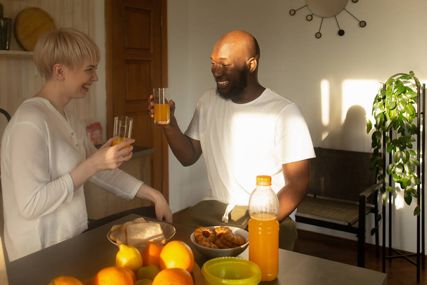 το Happy ζευγάρι πίνουν χυμό, της Αφρικής Αμερικής και της Ευρώπης - Φωτογραφία, εικόνα