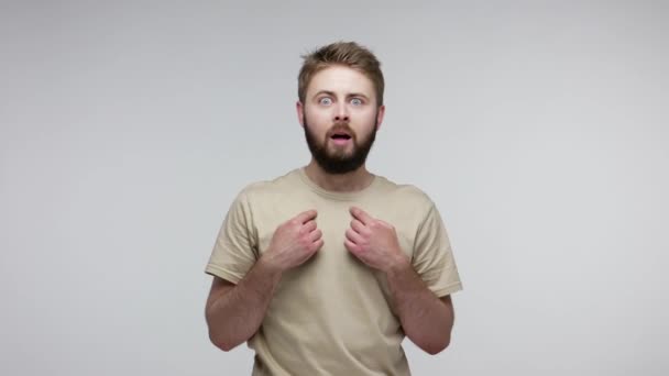 Wow, this is me! Amazed bearded man pointing himself, looking shocked surprised at camera and slapping his face to wake up, not believing in victory. indoor studio shot isolated on gray background - Materiał filmowy, wideo