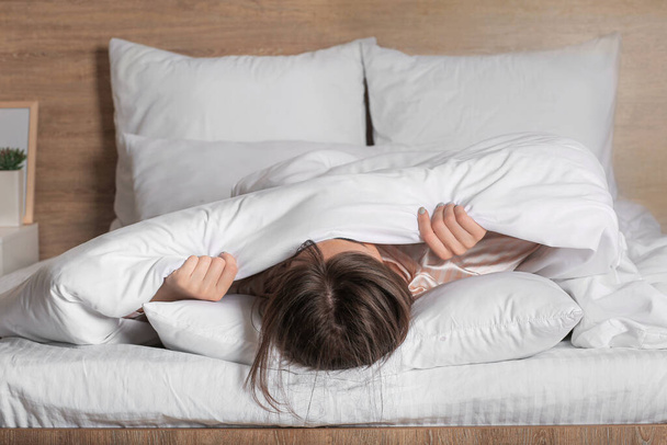 Mujer joven que sufre de privación del sueño en el dormitorio - Foto, Imagen