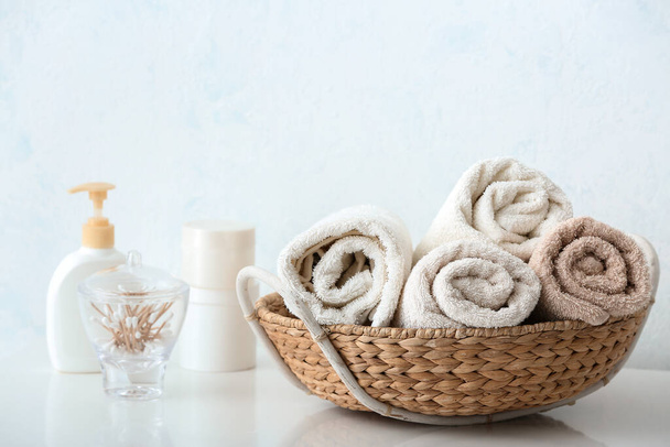 Basket with cotton towels on table in bathroom - Foto, Imagen
