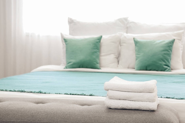 Toallas limpias en la cama en la habitación del hotel - Foto, Imagen