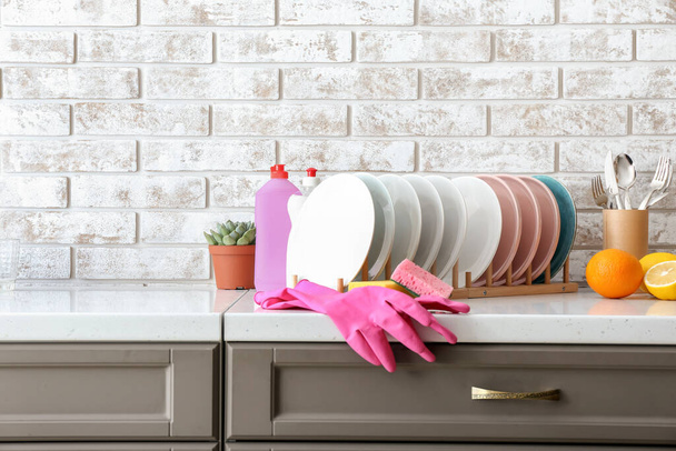 Чистые посуда и моющие средства на кухонном столе
 - Фото, изображение