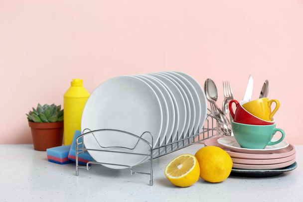 Sauberes Geschirr und Reinigungsmittel auf dem Küchentisch - Foto, Bild