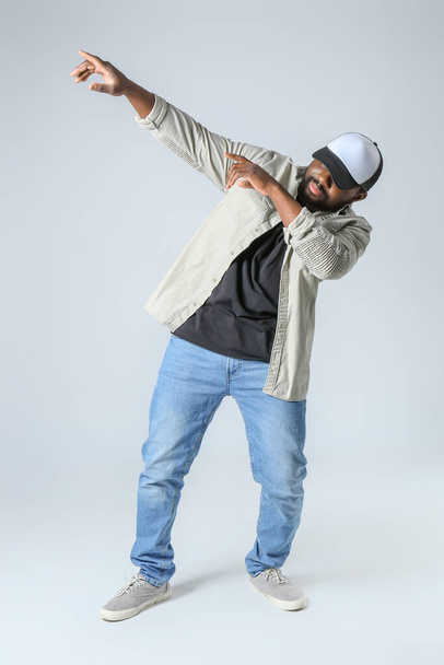 Male African-American hip-hop dancer on light background - Fotó, kép