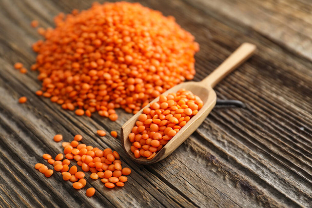 Scoop with red lentils on wooden background - Photo, Image