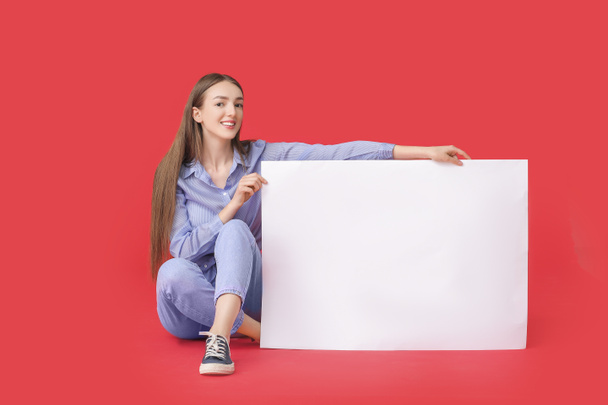 Junge Frau mit leerem Plakat auf farbigem Hintergrund - Foto, Bild