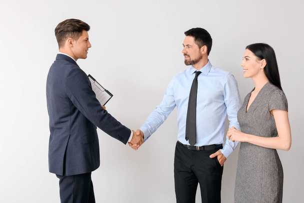 Business people shaking hands on light background - Foto, Imagen