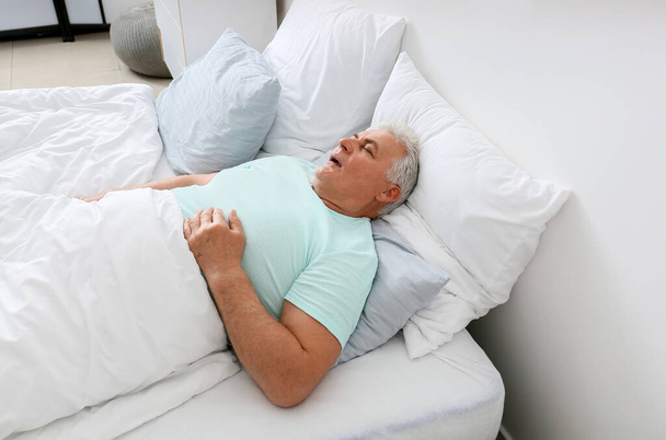 Starší muž chrápe, když spí v posteli. Problém apnoe - Fotografie, Obrázek