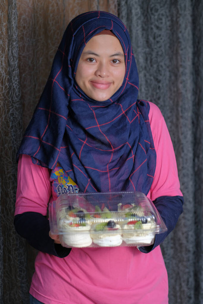 Schöne Mädchen im Hijab macht Pavlova Dessert. Lebensmittelindustrie - Foto, Bild
