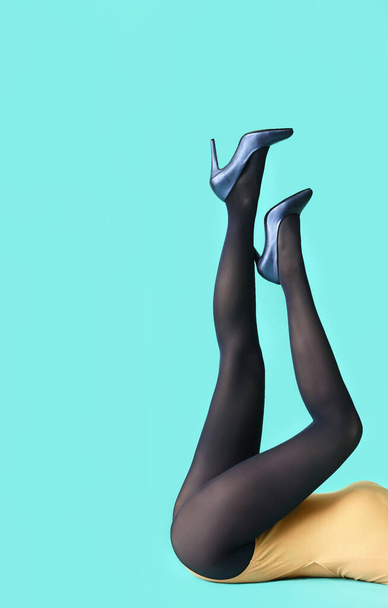 Beautiful young woman in tights on color background - Foto, afbeelding