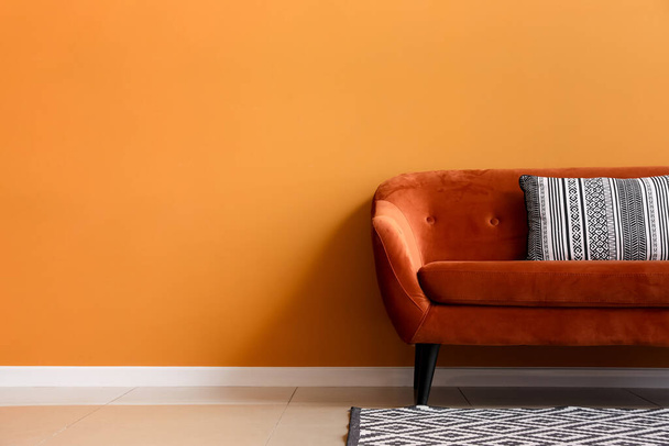 Stylish sofa near color wall in room - Foto, Bild