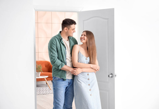 Happy couple in front of door at their new home - 写真・画像