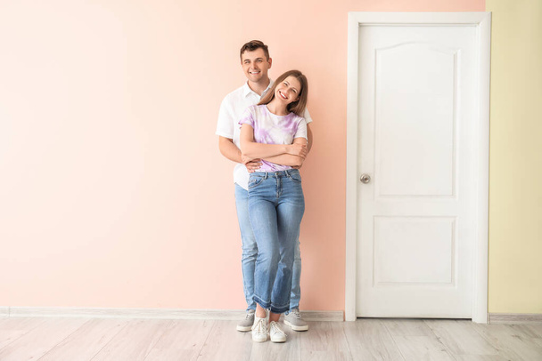 Happy couple near door at their new home - 写真・画像