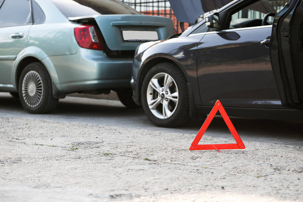 Σήμα στάσης έκτακτης ανάγκης κοντά σε σπασμένα αυτοκίνητα μετά από ατύχημα στο δρόμο - Φωτογραφία, εικόνα