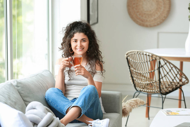 Piękna młoda kobieta pije gorącą herbatę w domu - Zdjęcie, obraz
