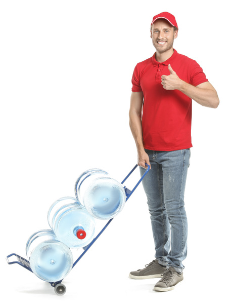 Delivery man showing thumb-up gesture with bottles of water on white background - Foto, Bild