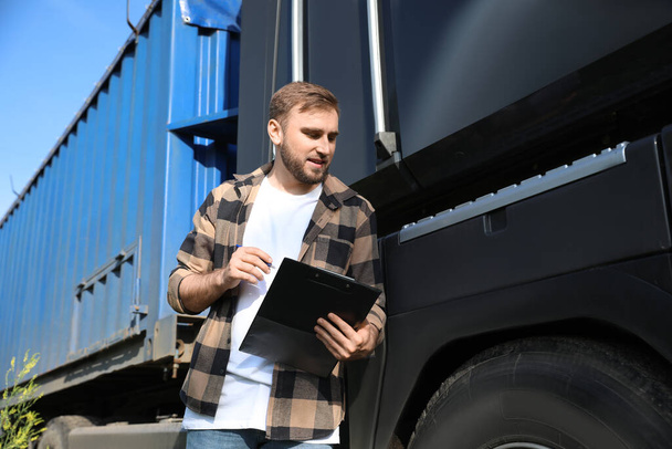 Άντρας οδηγός κοντά σε μεγάλο φορτηγό σε εξωτερικούς χώρους - Φωτογραφία, εικόνα