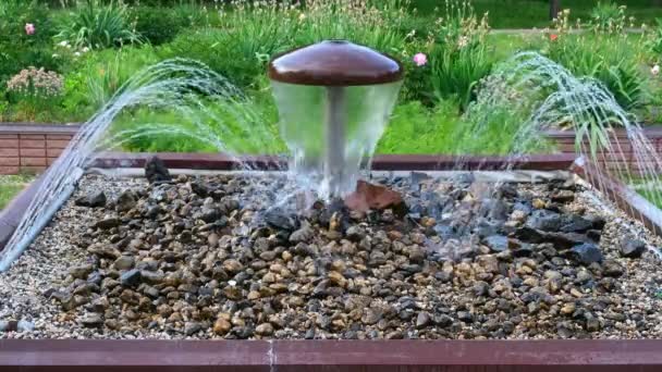 Koristeellinen sieni suihkulähde vuotaa taustalla vehreyden kaupungin Park. - Materiaali, video