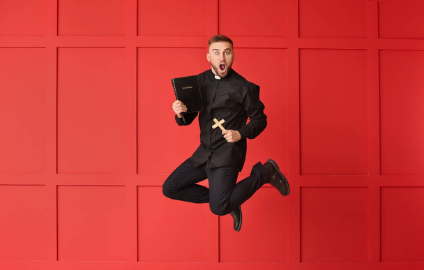 Прыжки молодой священник на цветном фоне
 - Фото, изображение