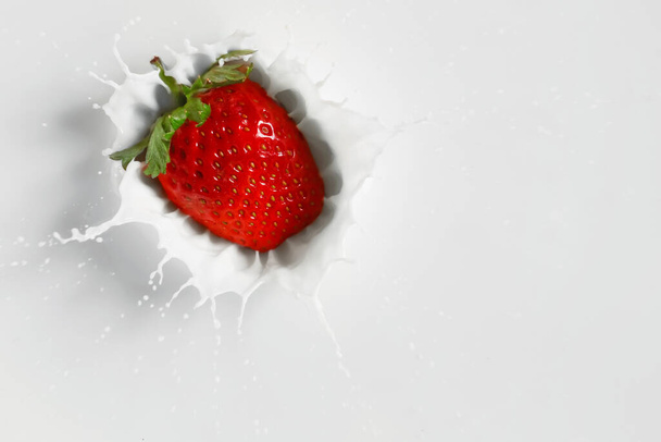 Falling of fresh strawberry into milk - Фото, зображення