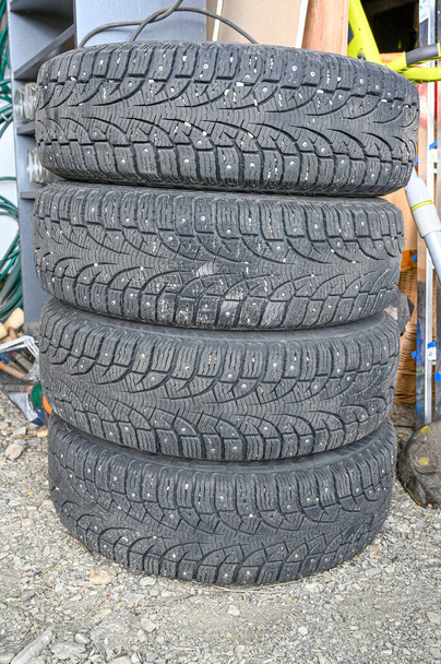 uma pilha de pneus de inverno cravejado em uma garagem
 - Foto, Imagem