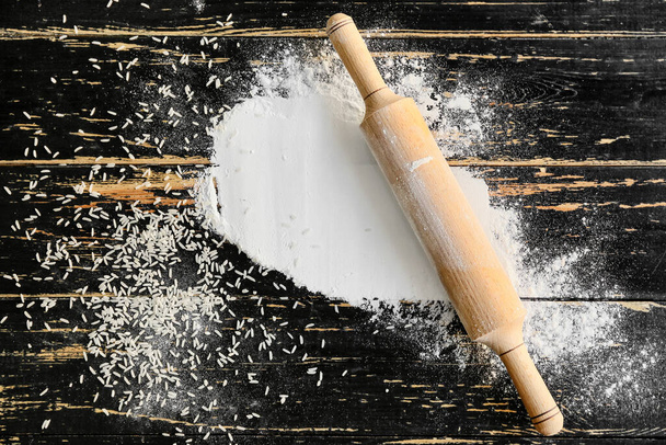 Rice flour with rolling pin on table - Fotoğraf, Görsel