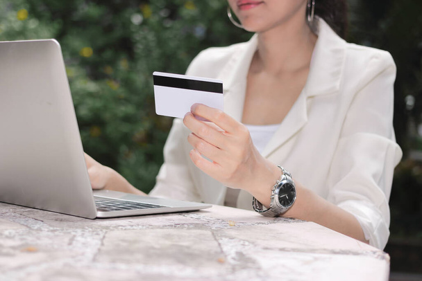 Atractiva joven mujer asiática con portátil y tarjeta de crédito para ir de compras en línea
. - Foto, imagen