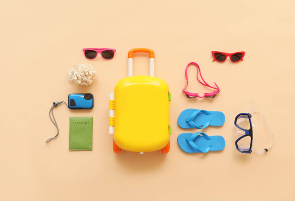 Koffer met strand accessoires op kleur achtergrond - Foto, afbeelding
