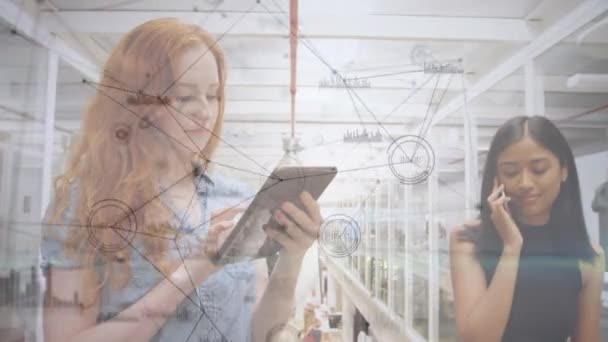 Animation of network of connections and data processing over two women using smartphone and digital tablet. Global business and network of connections concept digital composite. - Materiał filmowy, wideo