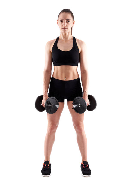 Young hispanic athletic woman working out with dumbbells, full length on white background - Photo, image
