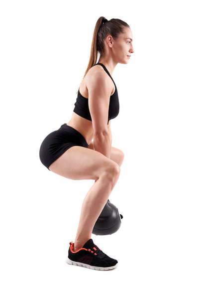 Young athletic woman doing workout with kettlebell isolated on white background - Photo, image