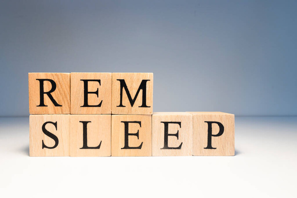 Rem sleep text from wooden cubes. Photo was taken in spot light on white background. - Photo, Image