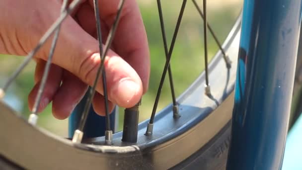 Pumping a bicycle wheel. Men's hands connect the pump to the wheels for pumping. - Footage, Video