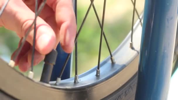 Pumping a bicycle wheel. Men's hands unscrew the cap from the wheels of the bicycle for pumping. Close-up. - Footage, Video