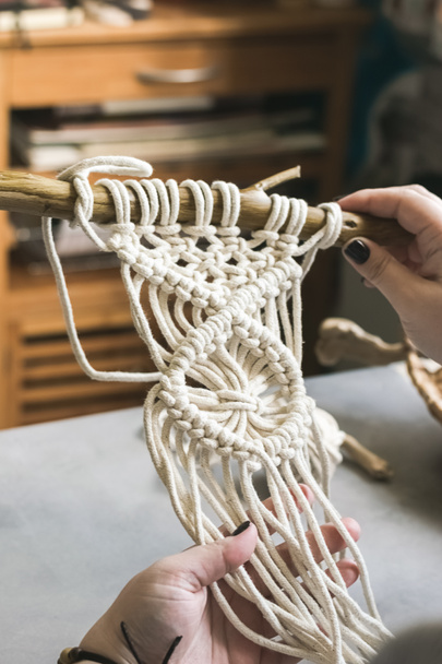 Female hands weave macrame the home workshop. Boho lifestyle. Hobby hobby concept. Selective focus - Photo, Image