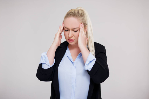 Business, Arbeit und Stresskonzept - Porträt einer müden, gestressten oder überarbeiteten schönen Plus-Size-Blondine mit Kopfschmerzen - Foto, Bild