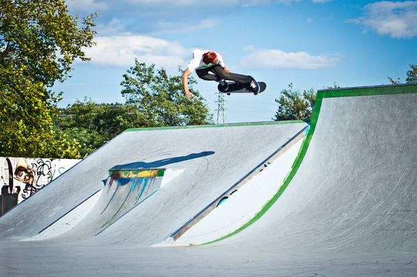 Skater flying over the skatepark on a sunny morning - Foto, Bild