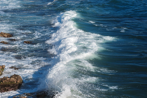 Ocean wave background breaking sea water rocky shore rough seas turquoise water gradient foam. Big waves at open sea. Summer monsoon. White crest of a sea wave. - Photo, Image