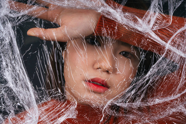 Nuori aasialainen thai musta lyhyet hiukset nainen kääri muovi sellofaani. - Valokuva, kuva