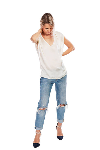 La giovane bionda in jeans e una maglietta bianca ci hanno pensato, a testa in giù. Isolato su uno sfondo bianco. A tutta altezza. Verticale. - Foto, immagini