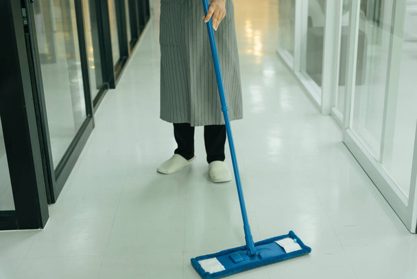 Покоївка використовує мопед прибирання підлоги в кімнаті квартири кондомініуму
. - Фото, зображення