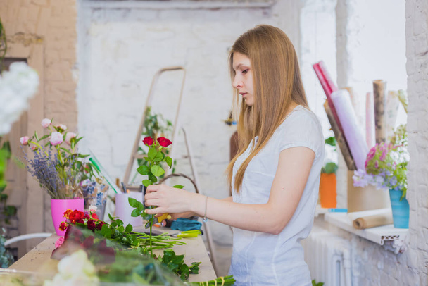 Fleuriste professionnel travaillant avec des fleurs au studio, boutique - vue latérale - Photo, image