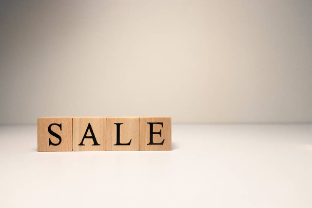 The word sale from wooden cubes. Photographs were taken in the spotlight. In white background. - Foto, imagen